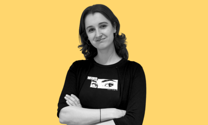 Black and white image of Olivia smiling on a yellow background