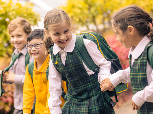 school children holding hands and smiling